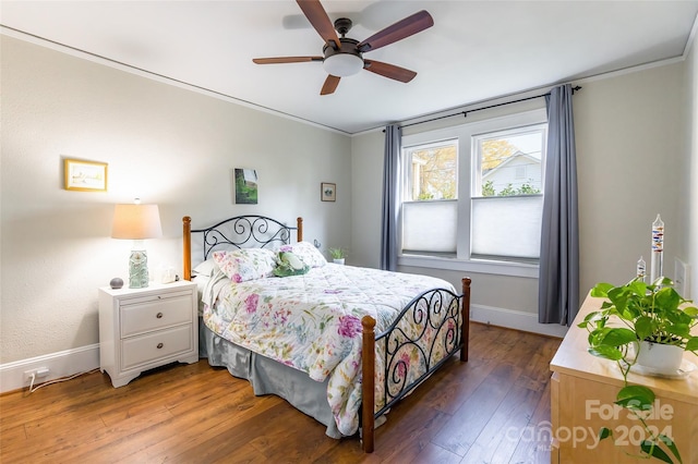 bedroom with dark hardwood / wood-style floors, ceiling fan, and ornamental molding