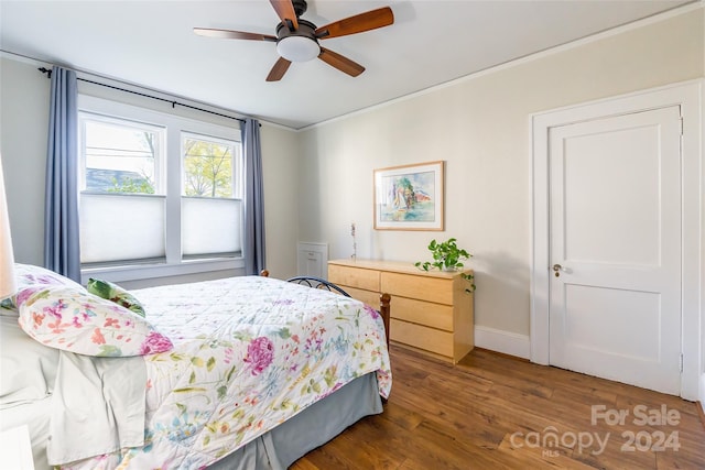 bedroom featuring ceiling fan, crown molding, and dark hardwood / wood-style floors