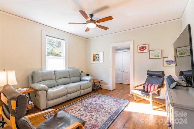 living room with ceiling fan, light hardwood / wood-style floors, and ornamental molding