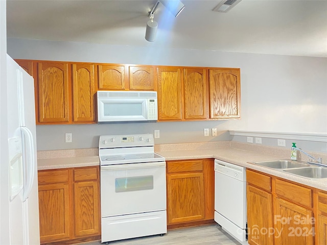 kitchen with light wood-type flooring, white appliances, rail lighting, and sink