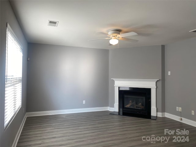 unfurnished living room featuring dark hardwood / wood-style floors and ceiling fan