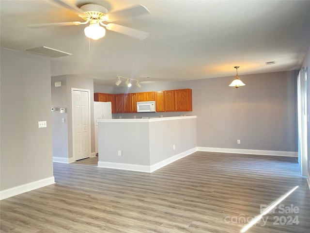 unfurnished living room featuring hardwood / wood-style flooring and ceiling fan