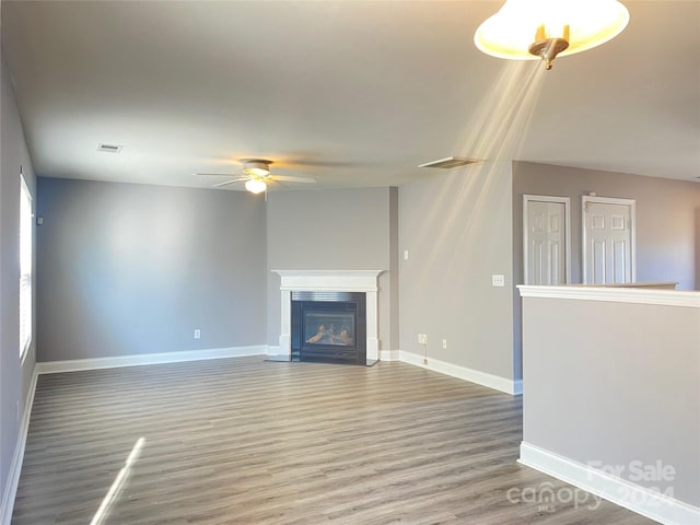 unfurnished living room featuring ceiling fan and hardwood / wood-style floors