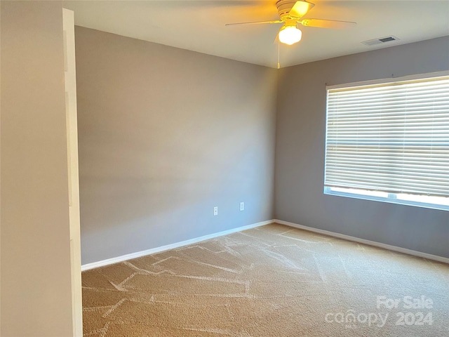 unfurnished room featuring ceiling fan, plenty of natural light, and light colored carpet