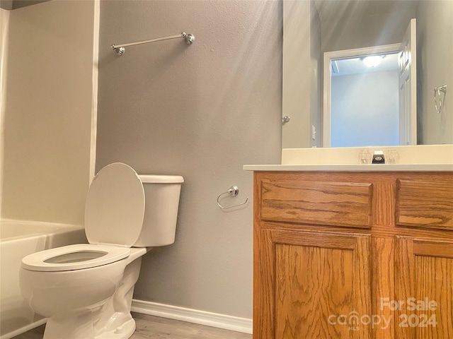 bathroom with vanity, toilet, wood-type flooring, and a tub