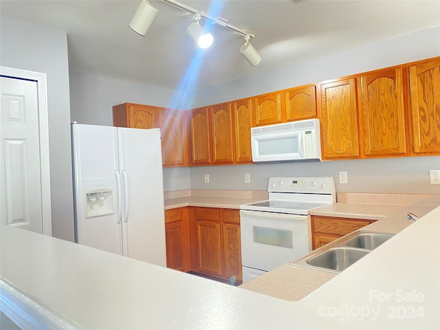 kitchen featuring sink, track lighting, and white appliances