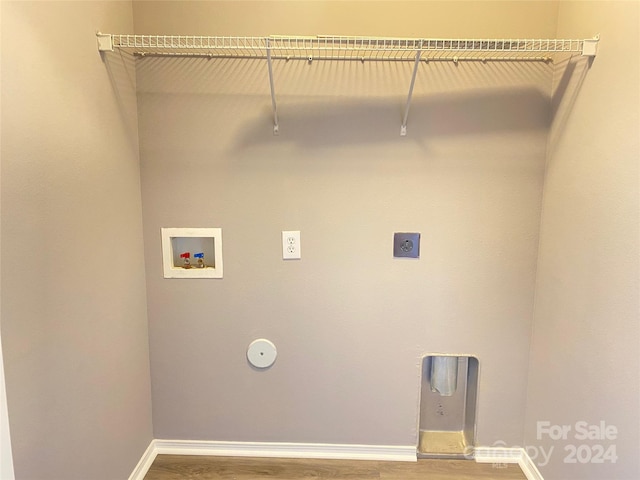 washroom with hookup for an electric dryer, hardwood / wood-style flooring, and washer hookup