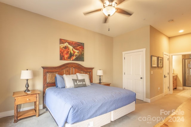 carpeted bedroom with ensuite bath and ceiling fan