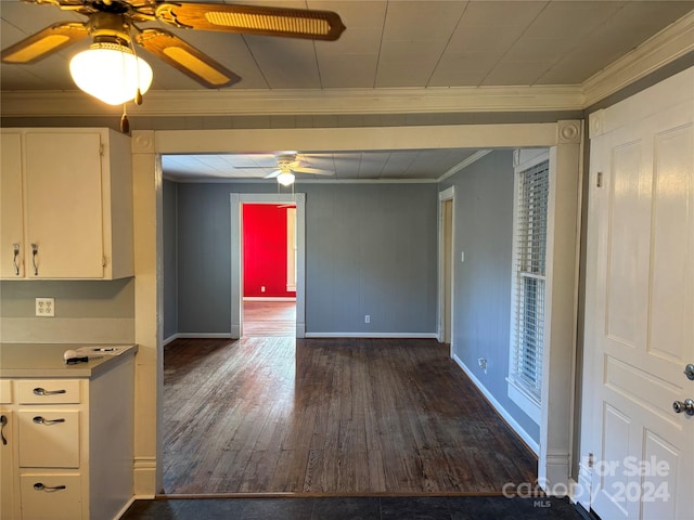 interior space with white cabinets, dark wood-type flooring, and ornamental molding