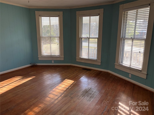 unfurnished room featuring wood-type flooring and crown molding