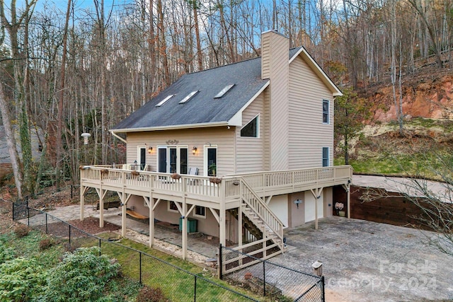 back of property featuring a wooden deck and a garage