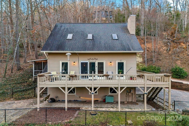 rear view of property featuring a wooden deck