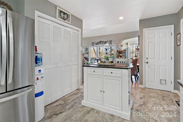 kitchen featuring white cabinets and stainless steel fridge