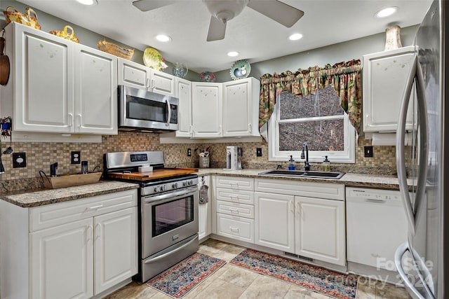 kitchen featuring white cabinets, backsplash, sink, and appliances with stainless steel finishes