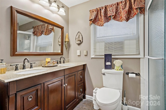 bathroom with vanity, toilet, and a shower with door