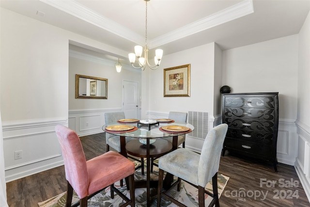 dining room featuring dark hardwood / wood-style floors, crown molding, a chandelier, and a tray ceiling