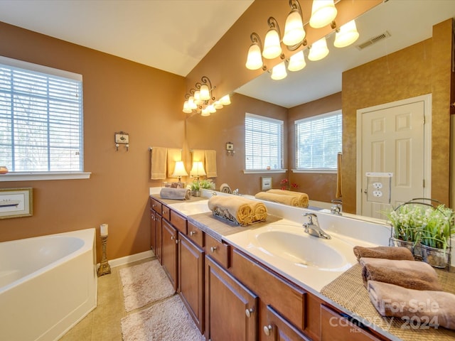 bathroom featuring tile patterned flooring, a bathtub, vanity, and a notable chandelier