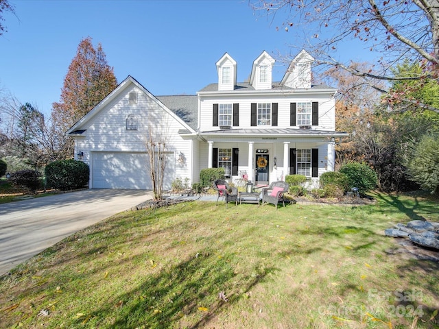 view of front of property featuring a porch, a garage, and a front lawn