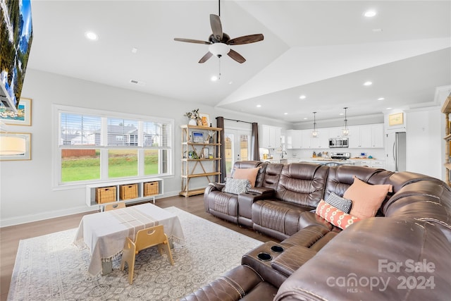 living room with wood-type flooring, ceiling fan, and lofted ceiling