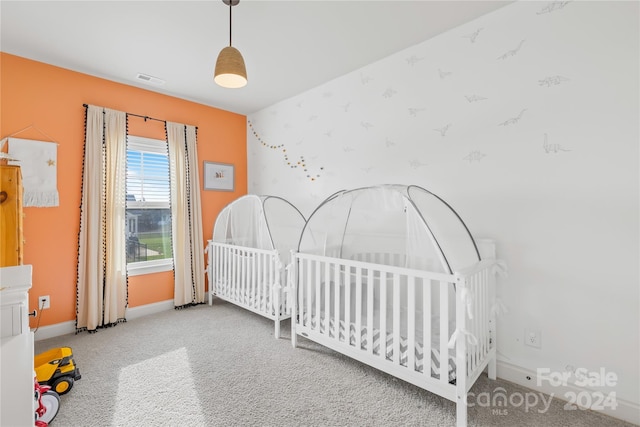 carpeted bedroom with a nursery area