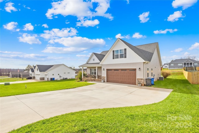 view of front of property with a front yard, central AC, and a garage