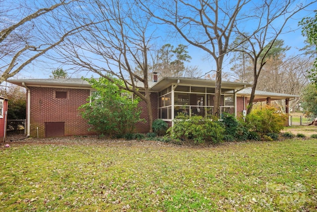 rear view of property with a yard and a sunroom