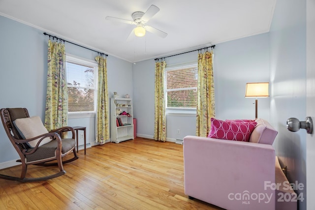 living area with ceiling fan, crown molding, and light hardwood / wood-style floors