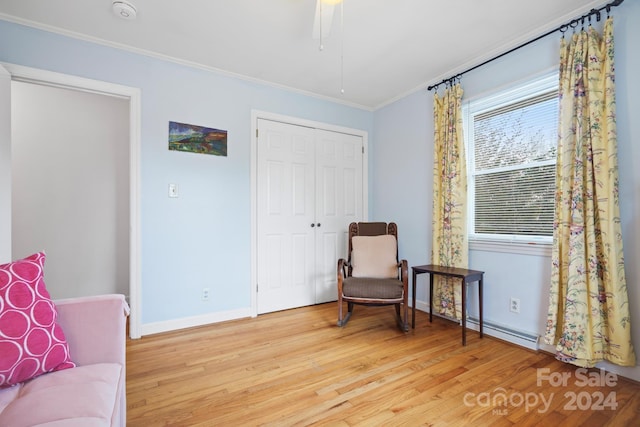 living area featuring crown molding, ceiling fan, light hardwood / wood-style floors, and a baseboard radiator