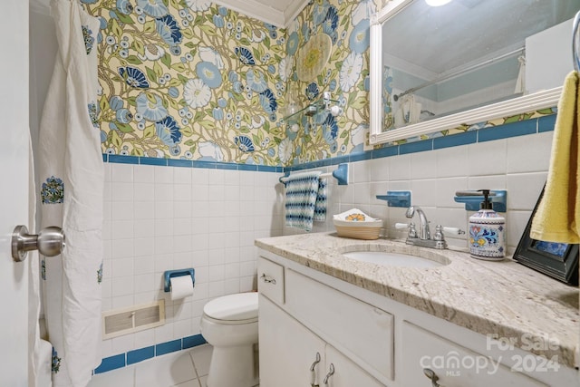 bathroom with vanity, crown molding, tile patterned flooring, toilet, and tile walls