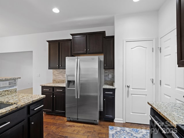 kitchen featuring dark wood-type flooring, backsplash, stainless steel refrigerator with ice dispenser, dark brown cabinetry, and light stone countertops