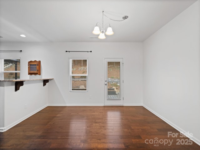 interior space with dark wood-type flooring and a chandelier