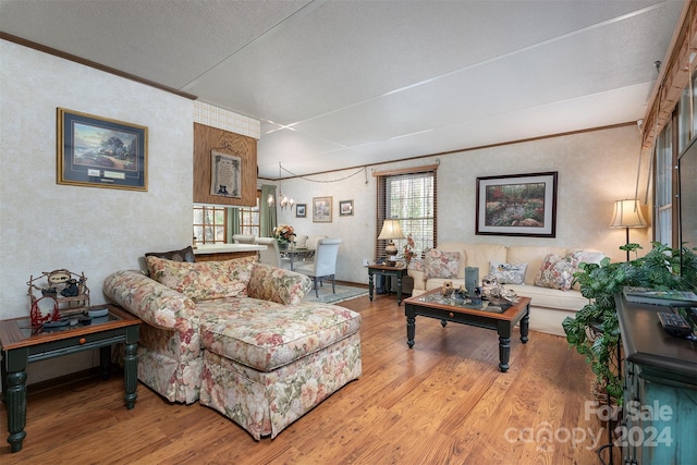 living room with light hardwood / wood-style floors, crown molding, a textured ceiling, and a chandelier