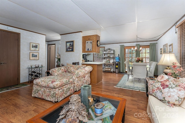 living room featuring hardwood / wood-style floors, an inviting chandelier, and ornamental molding