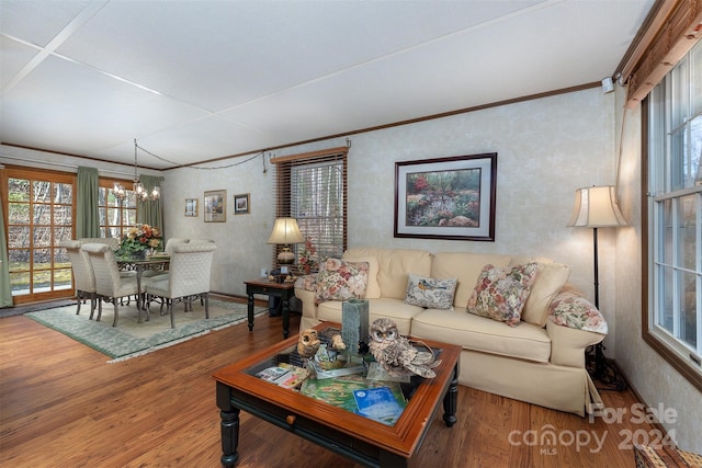 living room featuring crown molding, hardwood / wood-style floors, and a chandelier