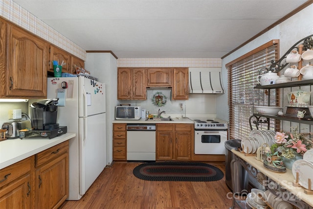 kitchen with sink, ornamental molding, ventilation hood, white appliances, and hardwood / wood-style flooring