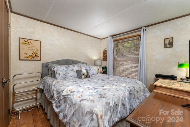 bedroom featuring a textured ceiling, hardwood / wood-style flooring, and crown molding