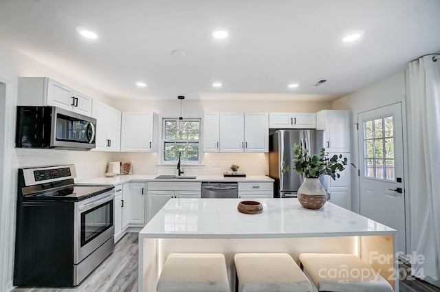 kitchen with pendant lighting, stainless steel appliances, a wealth of natural light, and sink