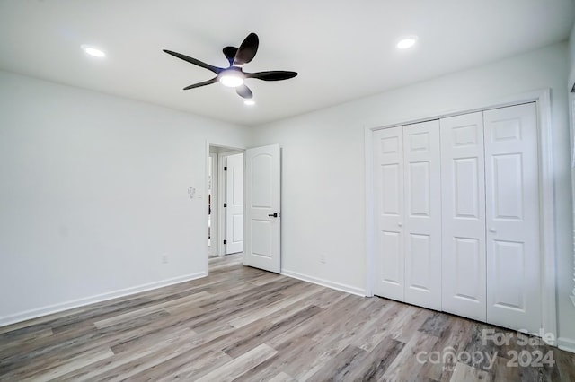 unfurnished bedroom with ceiling fan, light hardwood / wood-style floors, and a closet