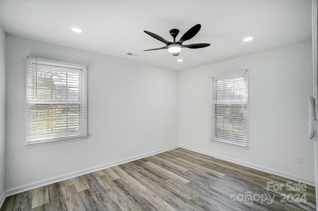 unfurnished room with ceiling fan, light wood-type flooring, and a wealth of natural light