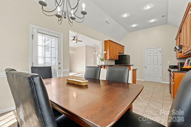 tiled dining space with ceiling fan with notable chandelier and vaulted ceiling