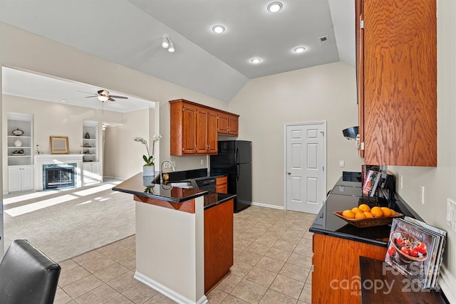 kitchen with kitchen peninsula, light carpet, black refrigerator, vaulted ceiling, and sink