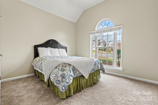 carpeted bedroom with lofted ceiling and multiple windows