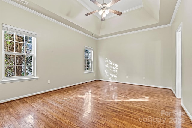 unfurnished room with a tray ceiling, crown molding, wood-type flooring, and ceiling fan