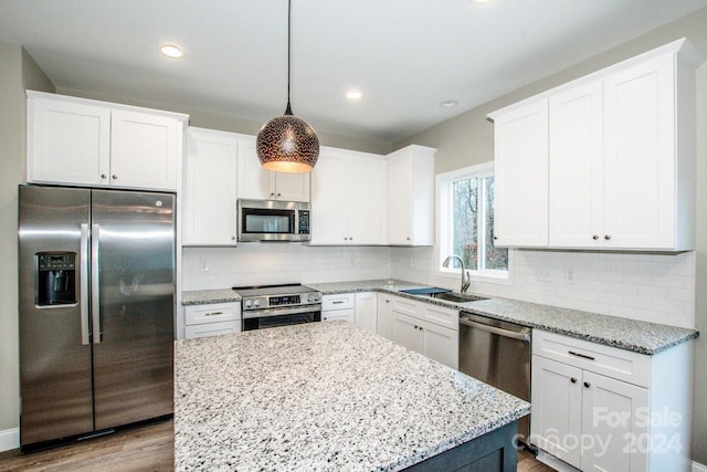 kitchen with white cabinets, sink, hanging light fixtures, light wood-type flooring, and appliances with stainless steel finishes