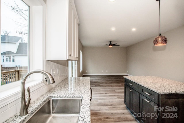 kitchen featuring a wealth of natural light, sink, pendant lighting, and wood-type flooring