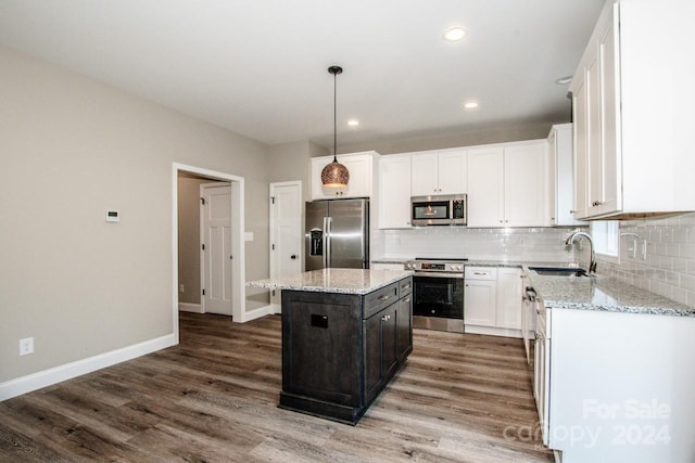 kitchen with sink, a kitchen island, stainless steel appliances, and wood-type flooring