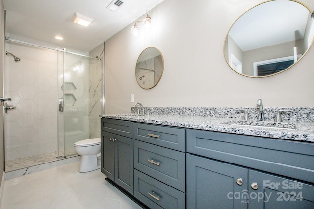 bathroom featuring tile patterned flooring, vanity, toilet, and walk in shower