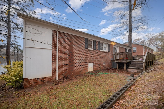 view of side of property featuring a deck and central AC unit