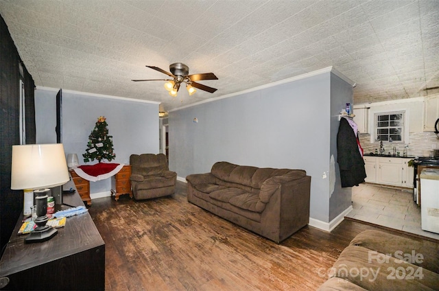 living room with crown molding, ceiling fan, dark wood-type flooring, and sink