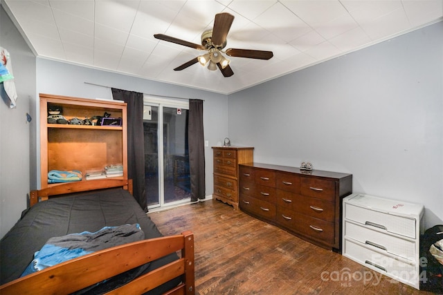 bedroom with ceiling fan, crown molding, and dark wood-type flooring